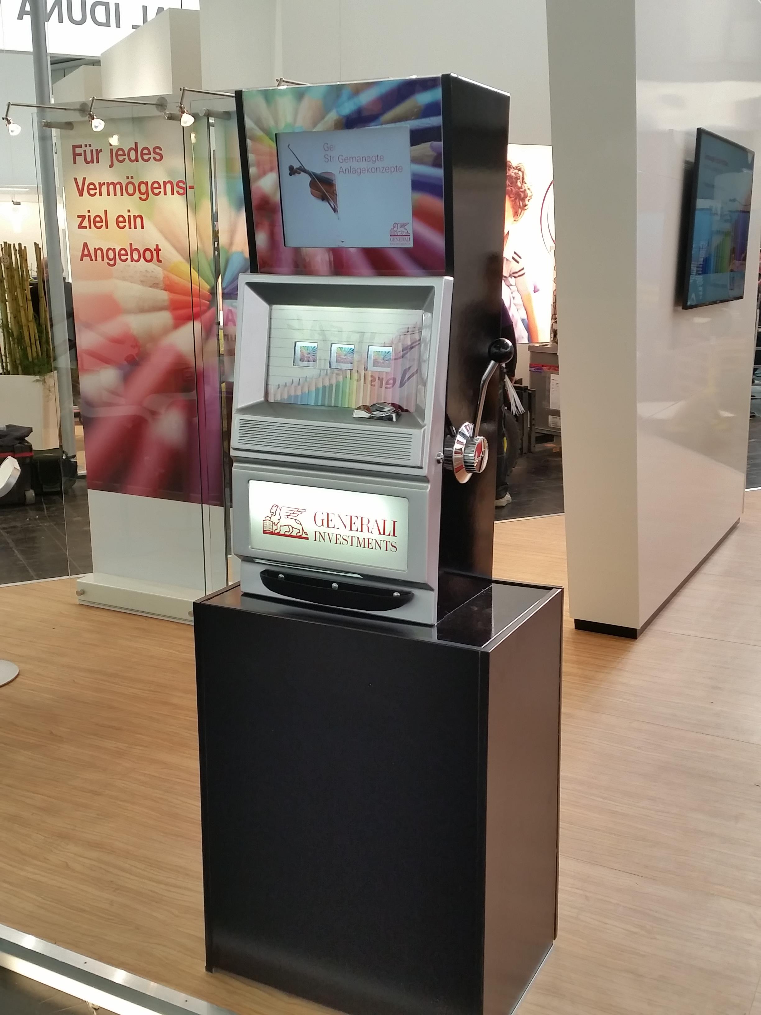 Einarmiger Bandit MAXI LCD mit Kundenbranding für Generali Investment auf der DKM in Dortmund zur Miete. Einarmiger Bandit MAXI LCD mit Kundenbranding für Generali Investment auf der DKM in Dortmund zur Miete.